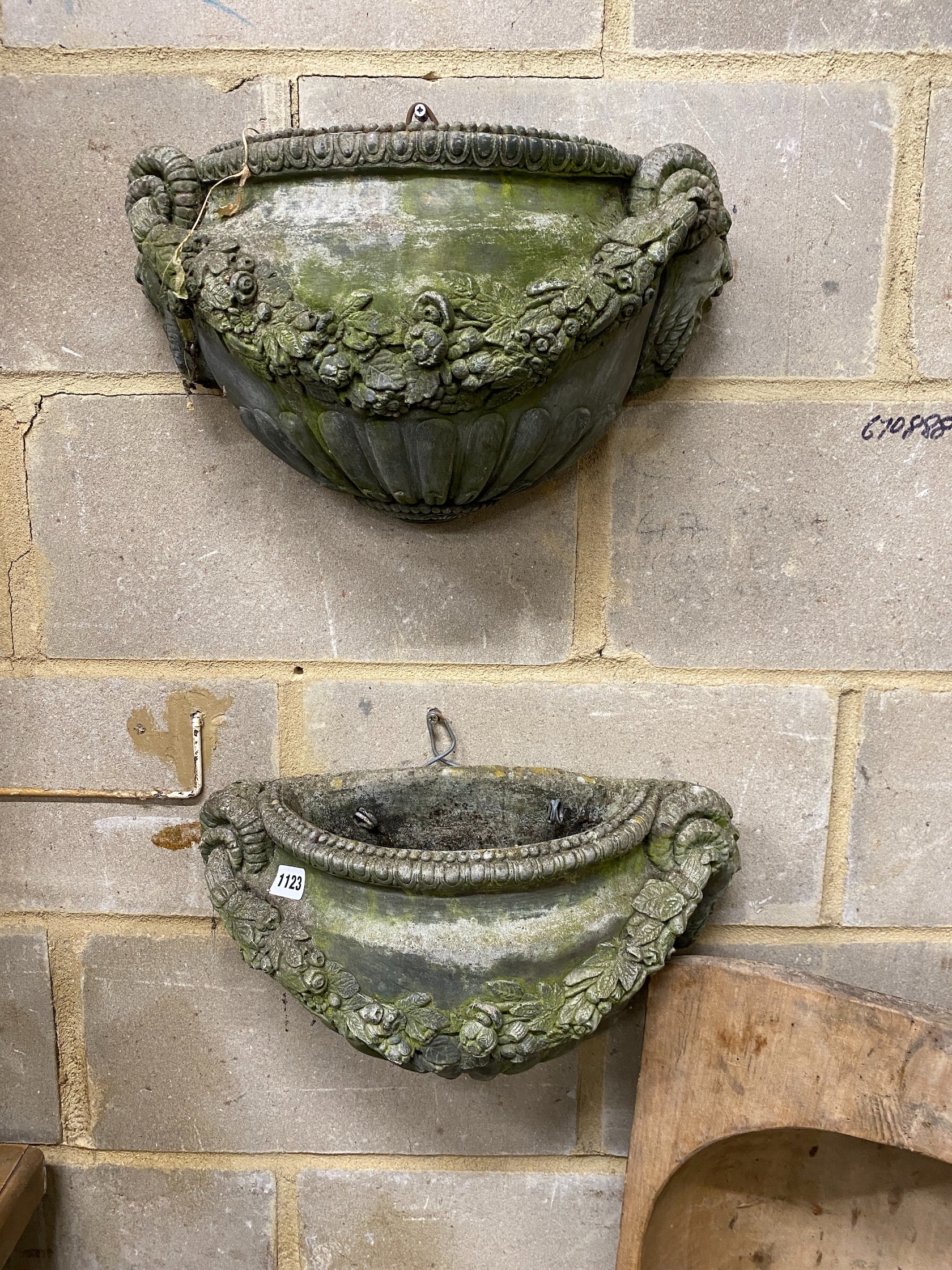 A pair of reconstituted stone garden wall planters, width 45cm, height 24cm